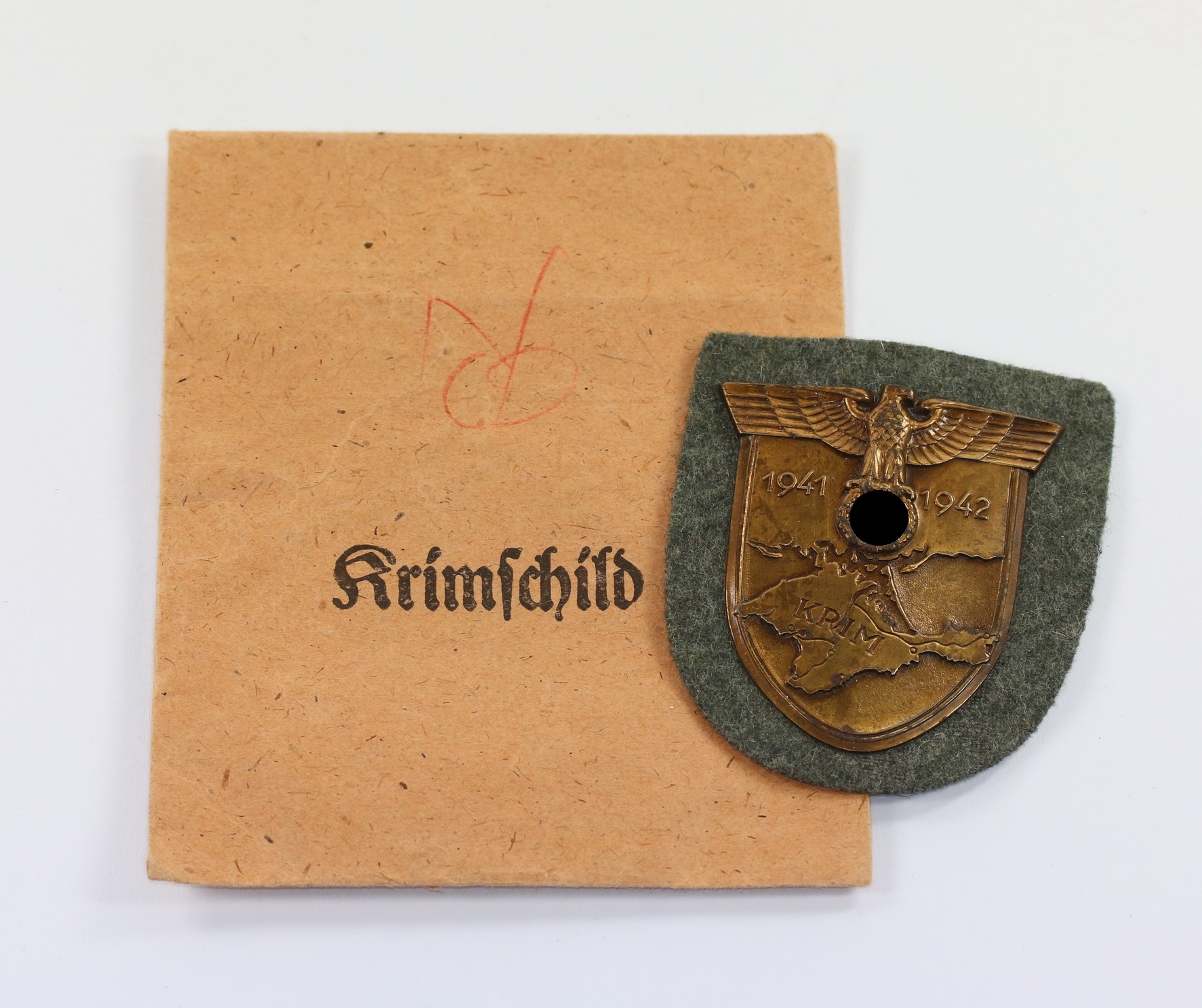 krimschild_auf_heeresstoff_friedrich_orth_in_tuete_1__1 Krimschild auf Heeresstoff, in Verleihungstüte, Friedrich Orth – Bild 1